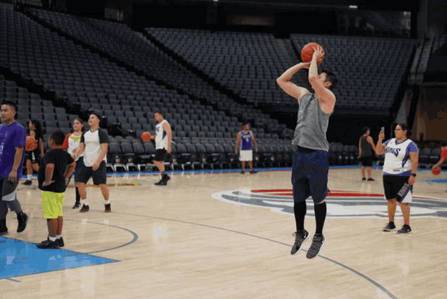 a man shooting a basketball on a basketball court wearing a shirt that says ' kings '