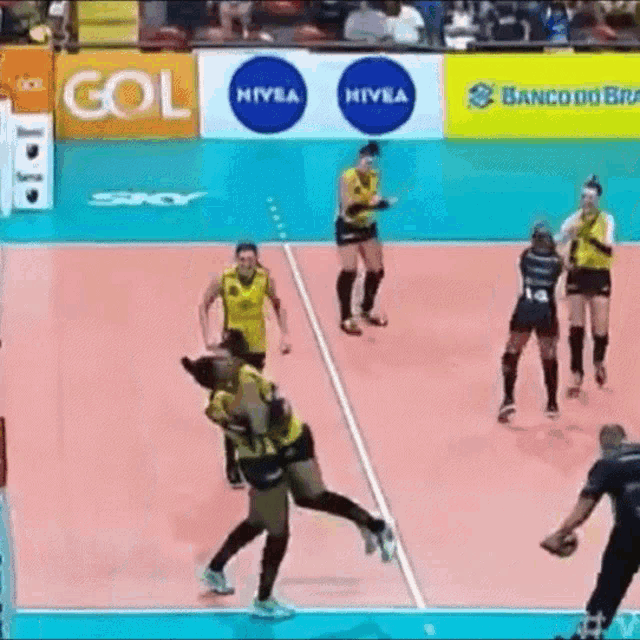 a volleyball game is being played in front of a banco do brasil banner