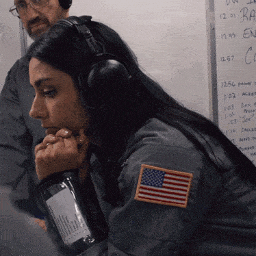 a woman wearing headphones has an american flag patch on her left shoulder