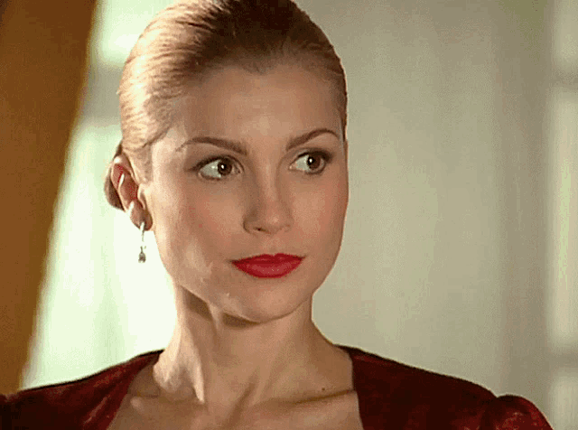 a close up of a woman 's face with red lips and earrings