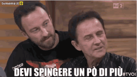 two men are sitting next to each other and one of them is saying devi spingere un po di piu