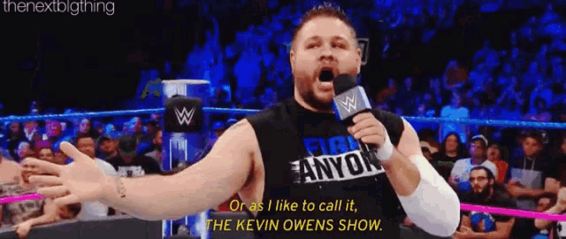 a wrestler is talking into a microphone while wearing a shirt that says " fight anyok "