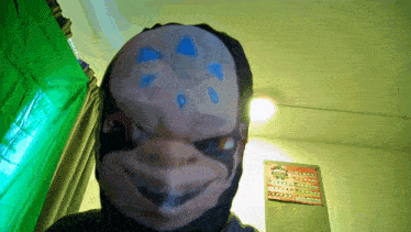 a person with a mask on their face stands in front of a green screen