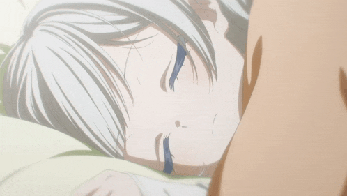 a girl with white hair and blue eyes is laying on a pillow