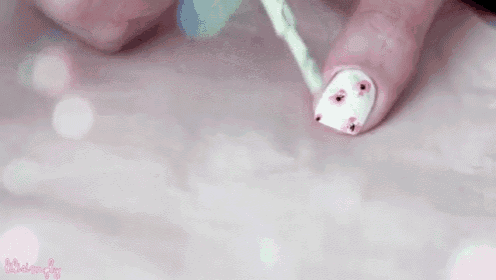 a woman is applying nail polish to her nails .