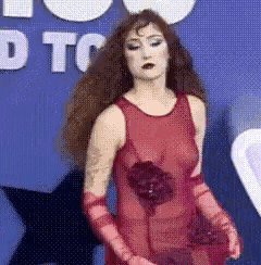 a woman is wearing a red dress and red gloves .