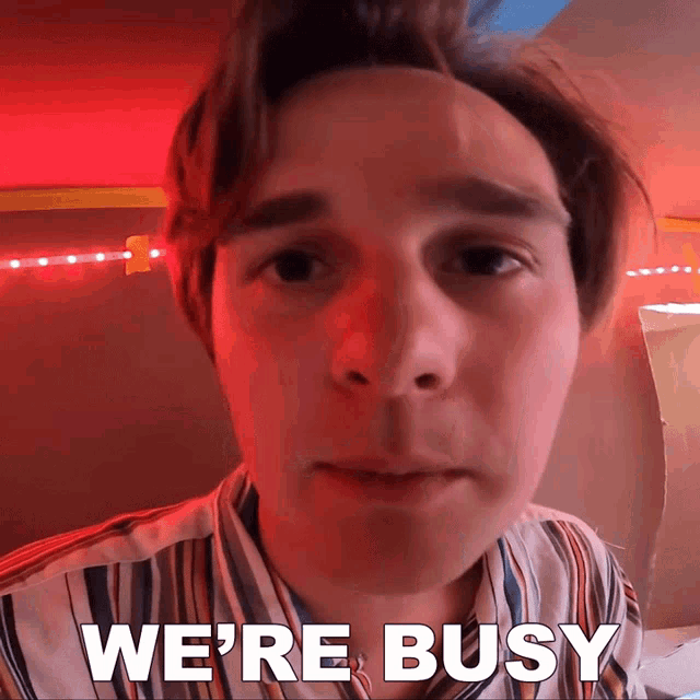 a close up of a man 's face with the words " we 're busy " on the bottom