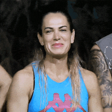 a woman in a blue kappa tank top smiles