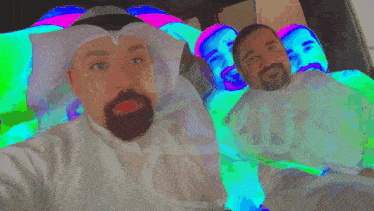 a man with a beard takes a selfie next to another man