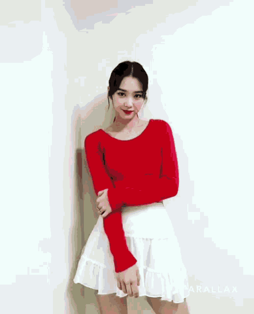 a woman wearing a red top and a white skirt