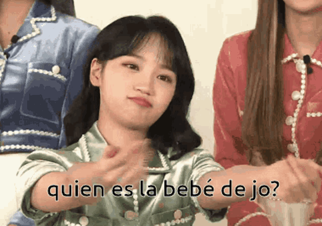 a girl in a green shirt with the words quien es la bebe de jo on the bottom