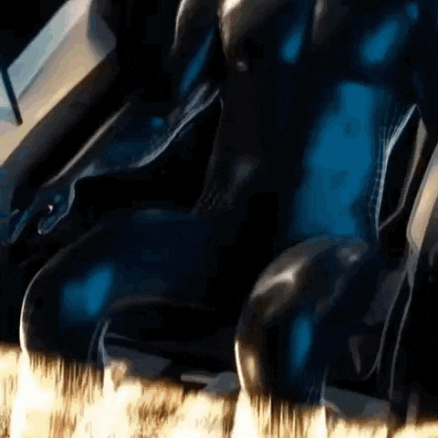 a close up of a person sitting in a car with a blue suit on .