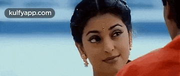 a woman in a red dress is smiling at a man .