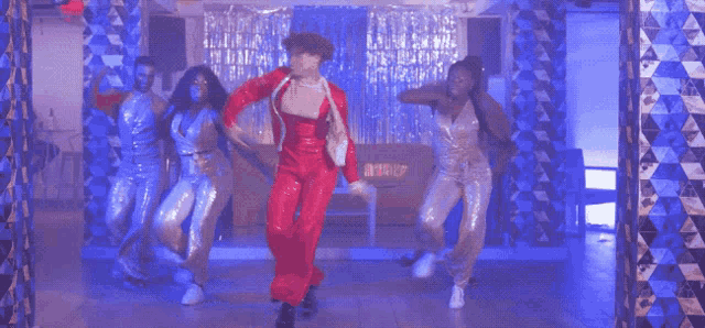 a man in a red suit is dancing in front of a sign that says ' r & r '