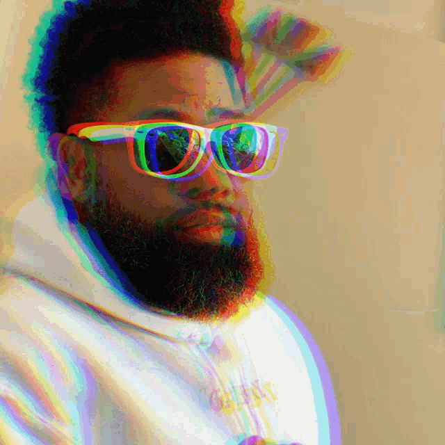 a man with a beard wearing sunglasses and a white hoodie with the word gang written on it