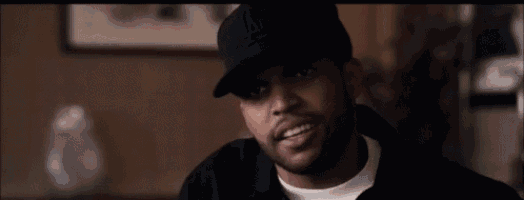 a man wearing a hat and a white shirt is making a funny face .