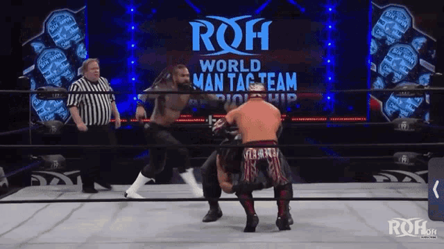 two wrestlers are fighting in a ring with a sign that says roh world man tag team