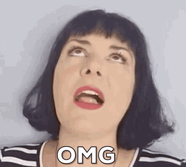 a woman with short black hair is making a funny face with her mouth open and the word omg on her face .