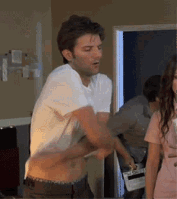 a man in a white shirt is standing in a room