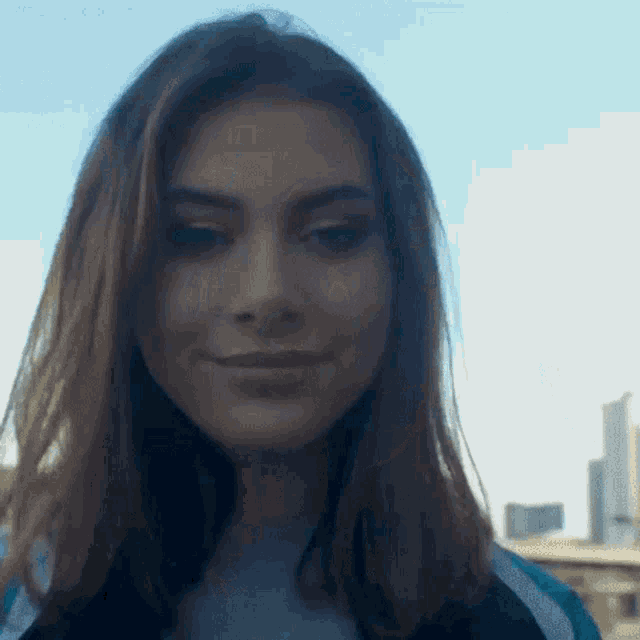 a woman with long brown hair is smiling and looking at the camera