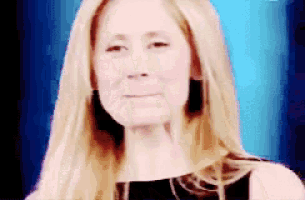 a close up of a woman 's face with a blue background