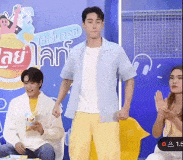 a man is standing in front of a group of people while holding a bag of lays chips .