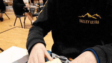 a person wearing a black valley ultra shirt is playing a game