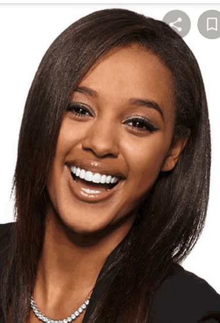 a woman is smiling and wearing a necklace