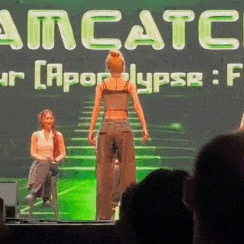 a woman stands on a stage in front of a screen that says amcatc