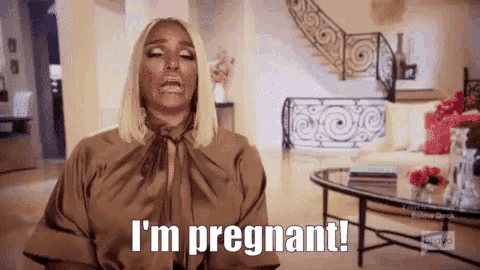 a woman in a brown shirt says i 'm pregnant