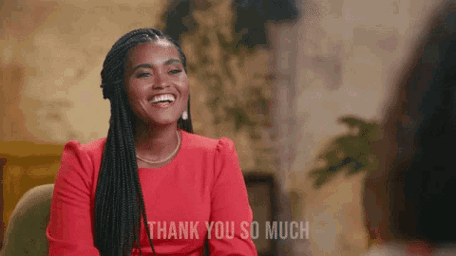 a woman in a red dress is sitting in a chair and says thank you so much