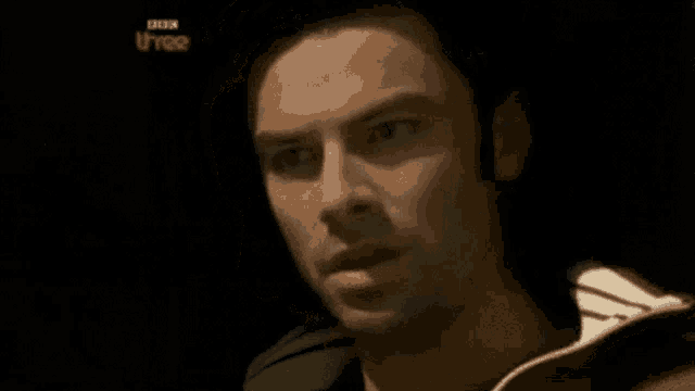 a close up of a man 's face with a black background .