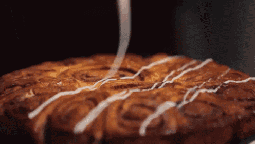 a close up of a cinnamon roll cake with icing on it