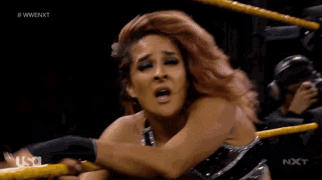 a woman in a wrestling ring with the word nxt on the bottom left