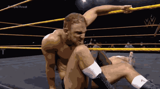 a man in a wrestling ring with the word triple threat on the bottom right