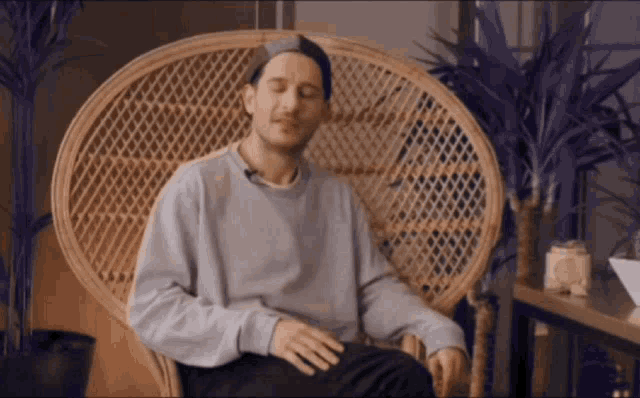 a man is sitting in a chair with his eyes closed