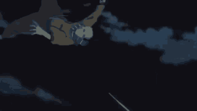 a person is flying through the air in front of a bright yellow sun in the dark .