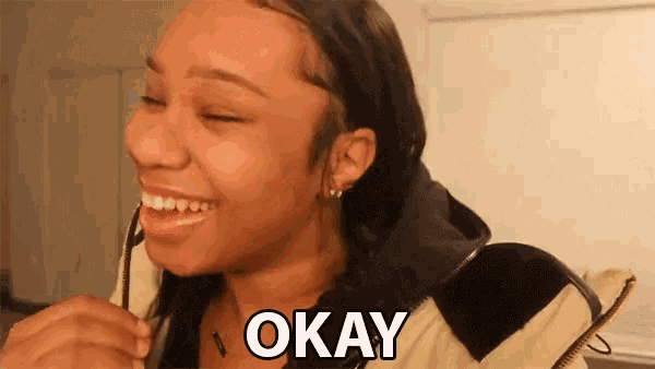a woman is smiling with the word okay above her head