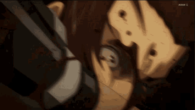 a close up of a person 's face with the letters nhk g on the bottom right