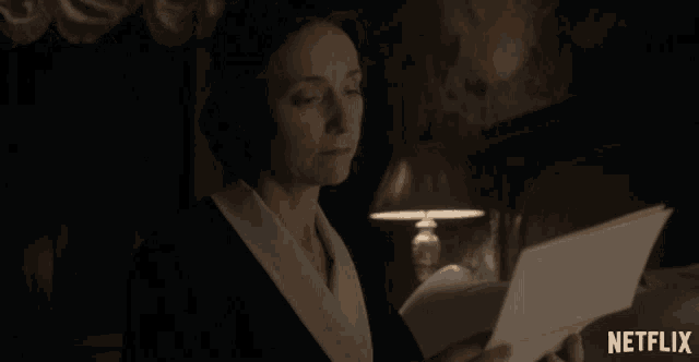 a woman holding a piece of paper with a netflix logo in the corner