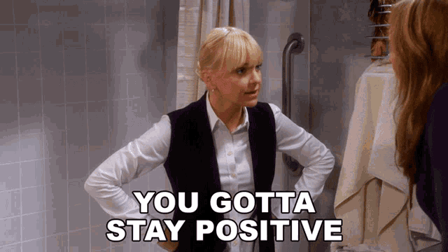 a woman standing in a bathroom with the words " you gotta stay positive "