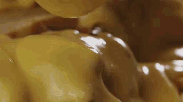 a close up of a person eating a hamburger with cheese and ketchup .