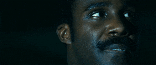 a close up of a man 's face with his eyes looking up