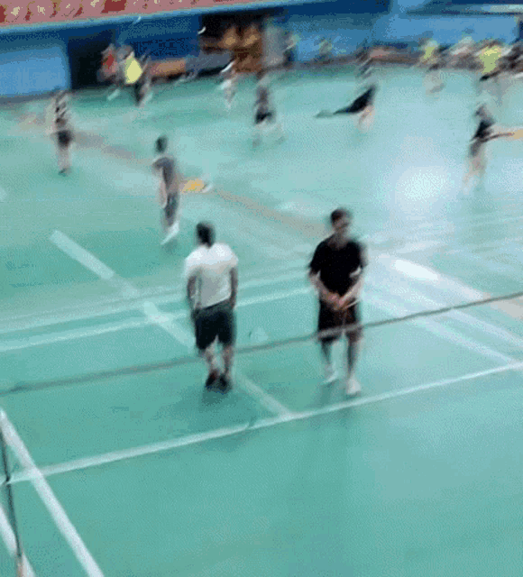 a group of people are playing a game of badminton