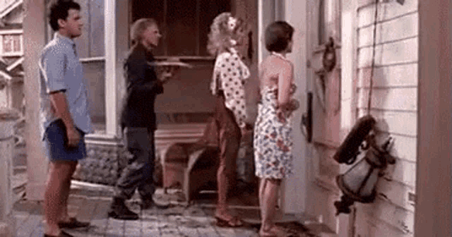 a group of people standing in front of a house .