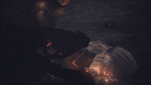 a person in armor laying on the ground with a fire coming out of his chest