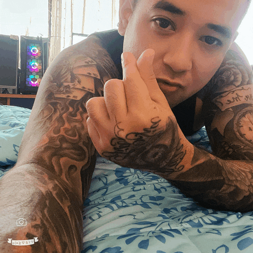 a man laying on a bed with a tattoo on his arm that says ' i 'm sorry '