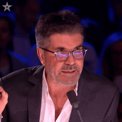 a man wearing glasses is speaking into a microphone