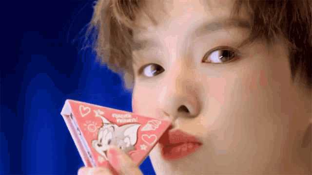 a close up of a person holding a box that says tom and jerry on it
