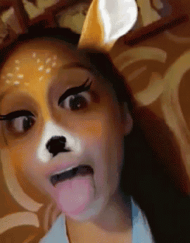 a close up of a woman wearing a deer mask with her tongue out